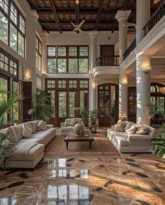 a large living room with high ceilings and lots of windows on the ceiling, along with two couches