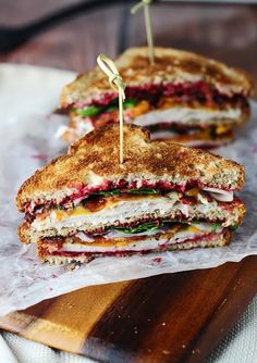 two grilled sandwiches sitting on top of wax paper