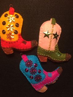 three different colored cowboy boots ornament on a black surface