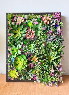 an art piece made out of plants on a wooden table