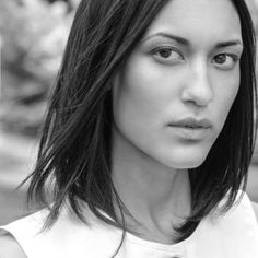 a black and white photo of a woman with shoulder length hair, wearing a blouse