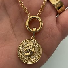 Fine casting made Queen Elizabeth inspired coin pendant in 18k gold filled. A great addition for those looking to have many pendants in a necklace or even bracelet. You may create your own collection, exploring the possibilities of jewelry making or diy (do it yourself) jewelry. Size with bail: 1" length Coin diameter: 0.75 inches Hypoallergenic jewelry Guarantee against tarnish Water resistant Rigorously manufactured under CA Prop 65 and EU standards Made in Brazil Have available the best jewel Gold Coin Necklace With Charms Pendant, Gold Coin Necklace With Charms, Gold Coin Necklace With Charms In Brass, Nickel-free Yellow Gold Coin Necklace With Round Pendant, Yellow Gold Coin Necklace With Nickel-free Round Pendant, Gold-plated Charm Necklace With Coin Pendant, Gold-plated Coin Pendant Charm Necklace, Nickel Free Gold Round Disc Coin Necklace, Gold Coin Necklace Nickel Free