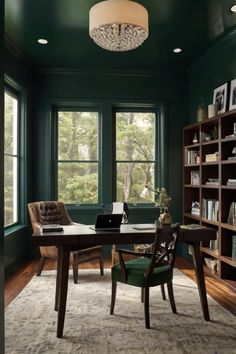 a home office with green walls and wood flooring, along with a rug on the floor