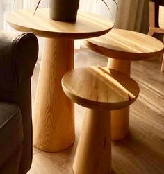 two wooden tables sitting on top of a hard wood floor next to a couch and chair