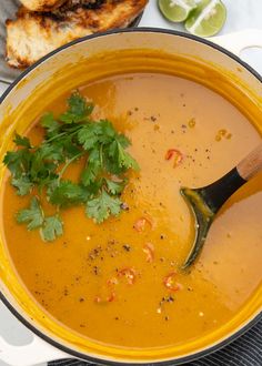 a yellow bowl filled with soup and garnished with cilantro