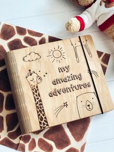 a wooden notebook with the words my amazing adventures written on it and a stuffed animal