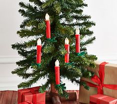 a small christmas tree with red candles and presents