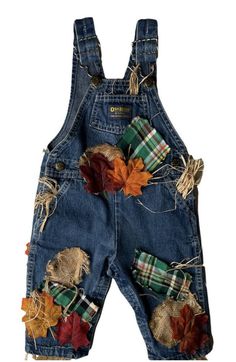 a pair of denim overalls with fall leaves and plaid bows on the back,