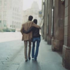 two people are walking down the street together