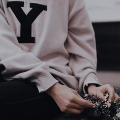 a person sitting down with their hands on the ground and flowers in front of them