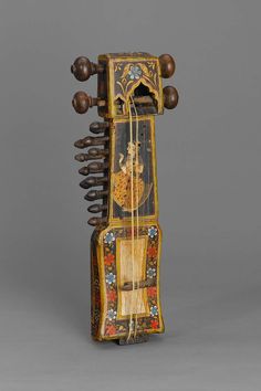 an ornately decorated musical instrument with wooden handles and knobs on the sides,