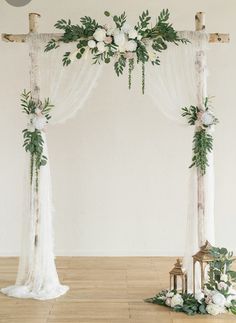 a wedding arch decorated with greenery and flowers