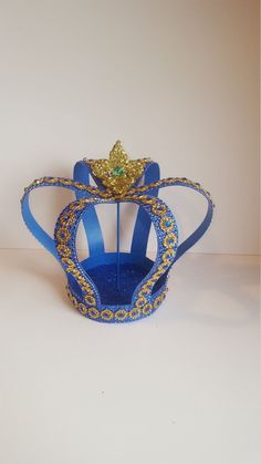 a blue and gold crown sitting on top of a white table next to a wall