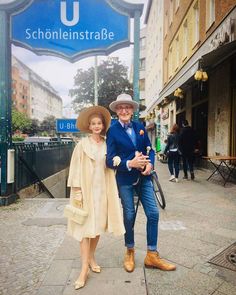 a man and woman are standing on the sidewalk