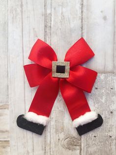 a red and white christmas bow hanging on a wooden wall