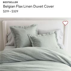 a bed that has some pillows on top of it and is made up with light green linens