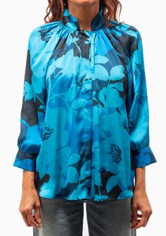 Smythe's Gathered Blouse in Cobalt Floral features a sophisticated stand up collar bridge, 3/4 sleeves and a covered button placket in a vivid floral pattern. 100% Polyester Dry Clean Model is 5’8” and wearing a size XS. Runs true to size, we recommend taking your usual size. Model’s Measurements: 26” waist 34” hips 34" bust Formal Blue Floral Print Tops, Elegant Blue Blouse With 3/4 Sleeves, Stand Up Collar, Button Placket, Online Purchase, Cobalt, Stand Up, Floral Pattern, Bridge