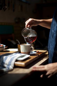 a person pouring tea into a cup