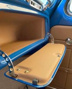 the interior of an old blue car with tan leather upholster and seat covers