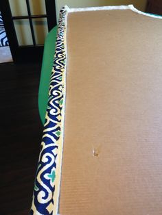 an open cardboard box on top of a table with a blue and white pattern covering it