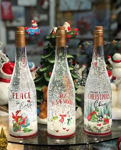 three christmas wine bottles sitting on top of a table