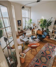 a living room filled with lots of furniture and plants on top of windowsills