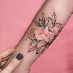 a woman's arm with a flower tattoo on it