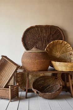 wicker baskets are stacked on top of each other in front of a white wall