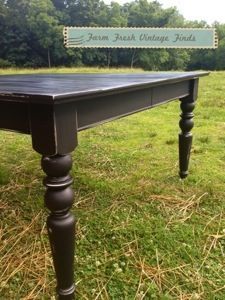 a black table sitting in the middle of a grass covered field next to a sign