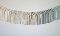 a white wall hanging with tassels on it