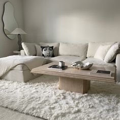 a living room with a couch, coffee table and mirror