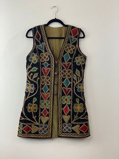 Made in Afghanistan, a rare find vintage sleeveless waistcoat. Hand embroidery on velvet. A very antique piece in mint condition.  Size: Male Medium Female Large Please contact for exact measurements. Note: Worn and minor signs of wear. Folk Style Sleeveless Vest For Festive Occasions, Sleeveless Vest With Intricate Embroidery For Festivals, Festive Bohemian Vest With Intricate Embroidery, Multicolor Embroidered Sleeveless Vest For Festivals, Vintage Vest For Festivals, Traditional Ceremonial Sleeveless Vest, Traditional Festive Vest With Intricate Embroidery, Traditional Fitted Vest With Intricate Embroidery, Festive Folk Style Sleeveless Vest