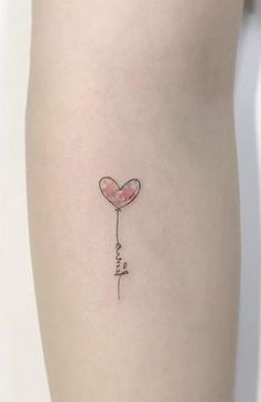 a heart shaped balloon with the word love written on it is attached to a woman's leg