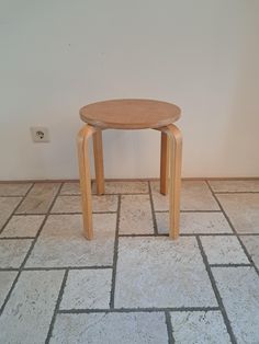 a small wooden table sitting on top of a tiled floor