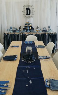 a table set up with blue napkins and place settings for an elegant dinner party