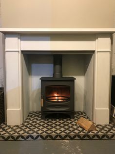 a fireplace with a wood burning stove in the center and tiled floor next to it