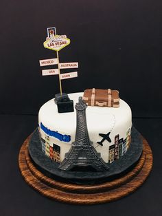 a cake that is decorated with the eiffel tower and luggage signs on it