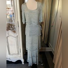 a dress is displayed on a mannequin in front of a mirror and door