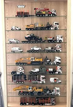 a wooden shelf filled with lots of toy trucks