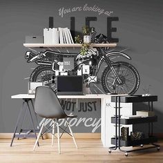 a desk with a bike on the wall and some bookshelves in front of it