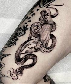 a black and white photo of a tattoo on the leg with an image of a snake