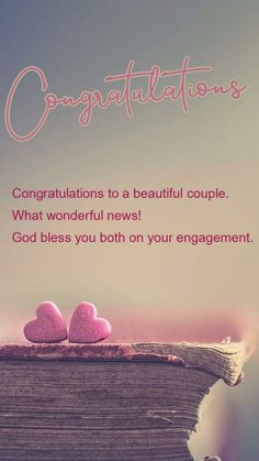 two pink hearts sitting on top of a book with congratulations written in the middle,