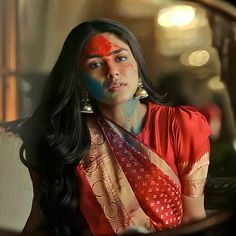 a woman with painted face sitting in front of a mirror