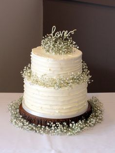 a wedding cake with white frosting and baby's breath