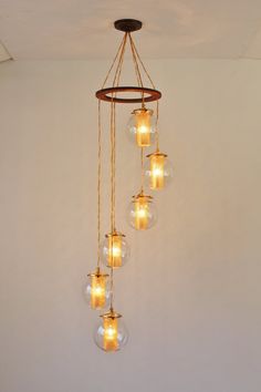 a chandelier with five glass globes hanging from it's center beam