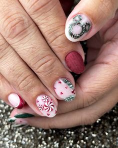 This charming nail design brings together a touch of winter Christmas colors with a wreath accent on the pinky and sweet peppermint swirls. The use of red and green polish shades provides a classic holiday feel, while the almond shape adds elegance. This simple yet festive look is ideal for any holiday gathering. Cute Short Winter Nails, Red Holiday Nails, Short Winter Nails, Nail Ideas Winter, Holiday Nail Ideas, Disney Christmas Nails, Disneyland Nails, Festive Holiday Nails, Christmas Press On Nails