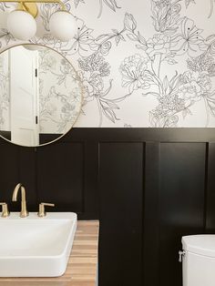 a white sink sitting under a mirror next to a toilet