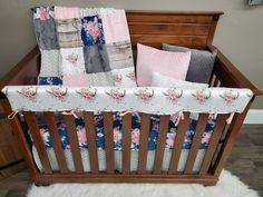 a baby crib with pink, blue and grey bedding