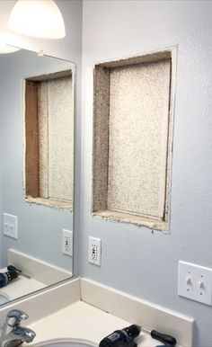 a bathroom sink with two mirrors and a light switch on the wall next to it