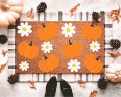 a door mat with flowers and pumpkins on it